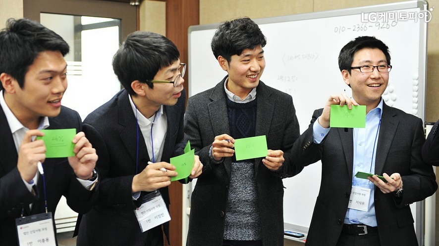 신입사원들과 함께 골든벨 수업에 참가한 대학생 에디터. 4명의 남자가 녹색의 종이를 한 장씩 들고 있다. 