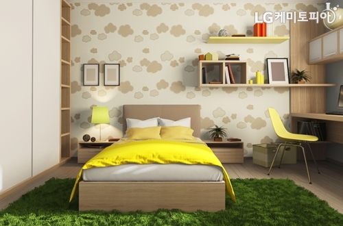 무늬가 그려진 벽지와 노란색 포인트 컬러를 이용한 아늑한 침실 전경