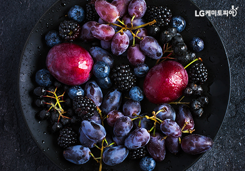 블루베리와 아로니아 등 검은색과 보라색의 채소와 과일이 원형 접시에 담겨있다.