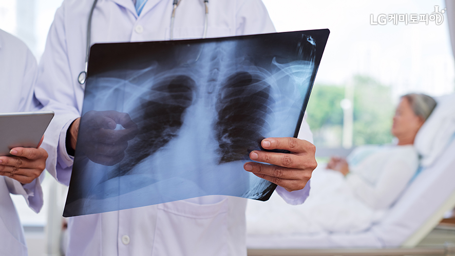 의사가 환자의 엑스레이 사진을 손에 들고 있다.
